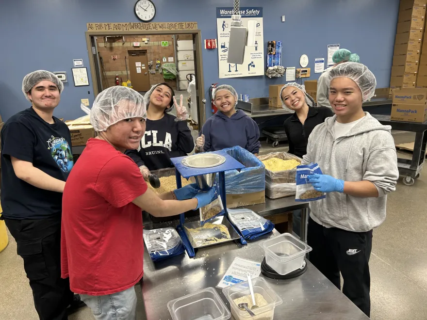 a photo of a group of Upward Bound students volunteering at Feed My Starving Children.