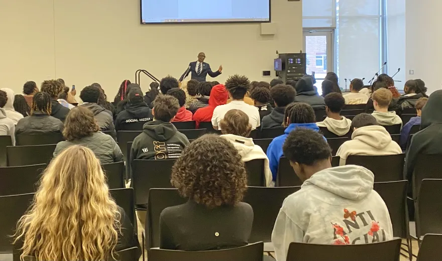 a photo of a guest speaking a room of student attendees on-campus for a Black History Month presentation.