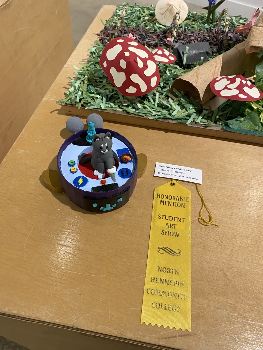 This is a photo of a ceramic piece from the 2025 Student Art Show, titled Daily Cat Activities. 