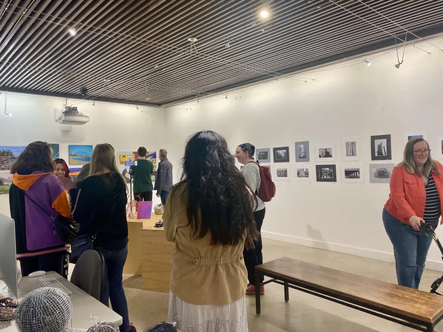 this is a photo of guests and students viewing art in the Art Gallery before the Student Art Show Reception. 