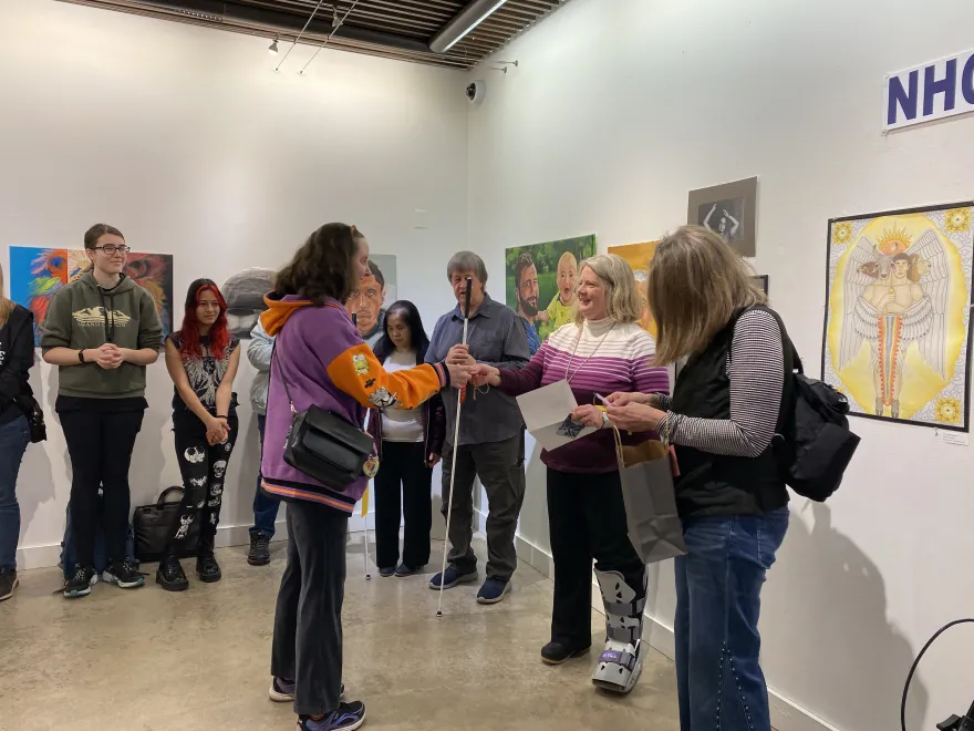 This is a photo of NHCC student, Jacquelyn Barry receiving an award at the 2025 Student Art Show. 