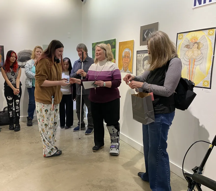 This is a photo of NHCC student, Kyden Aydt receiving a first-place award at the 2025 Student Art Show. 