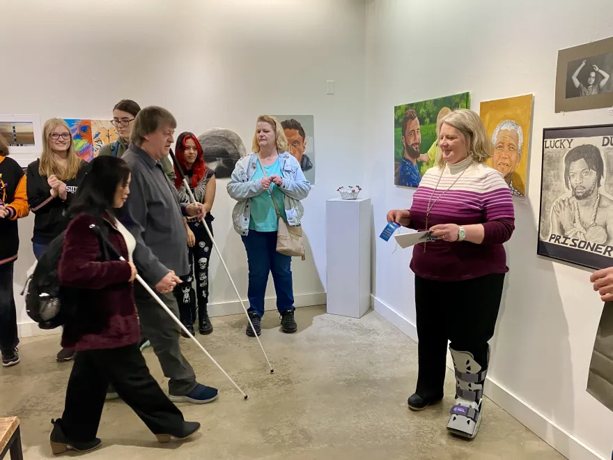 This is a photo of NHCC student, May receiving a first place award ribbon for ceramics at the 2025 Student Art Show.