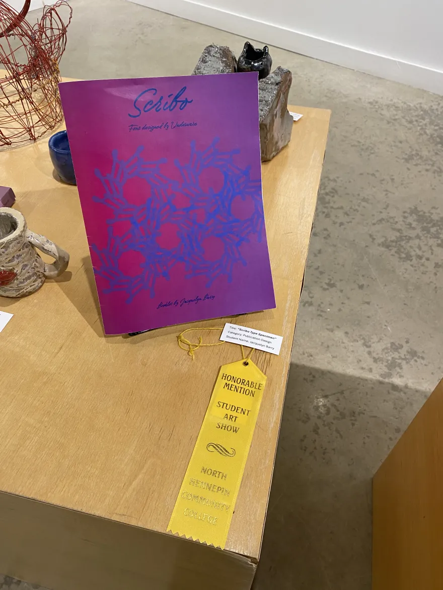 This is a photo of a package design that received an Honorable Mention award at the NHCC Student Art Show, titled, “Scribo Type Specimen.”