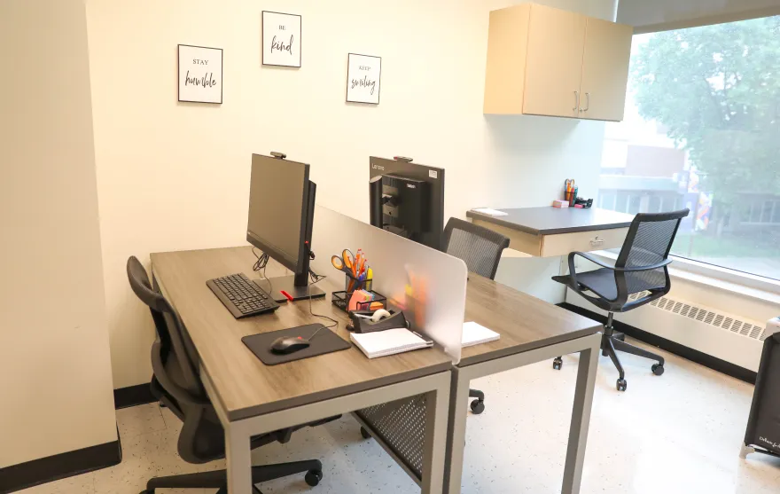tables and computers in a room with a window