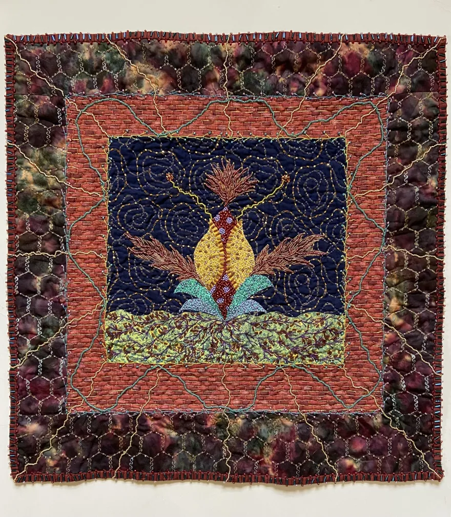this is a photo of a quilted patch, created with cotton, beads and embroidery thread. 