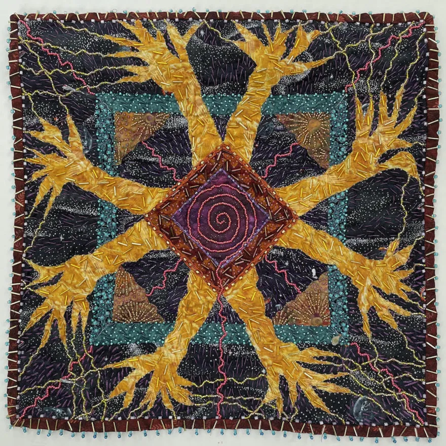 this is a photo of a quilted patch, created with cotton, beads and embroidery thread. 