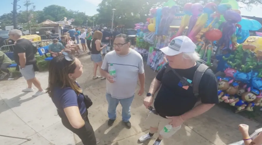this is a photo of NHCC General Maintenance Worker, Bob Newman and his friend with a Kare 11 journalist featured in a segment at the Minnesota State Fair talking about their favorite fair foods. 