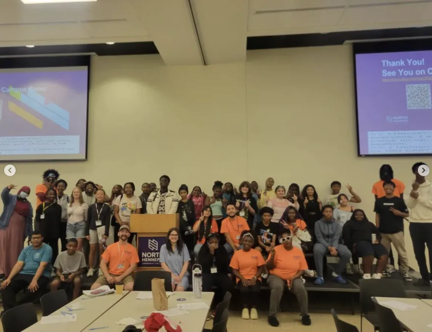 this is a photo of NHCC employee, Lindsey and a giant group of local youth students in the NHCC Grand Hall, visiting campus for an event designed to foster higher education conversations. 