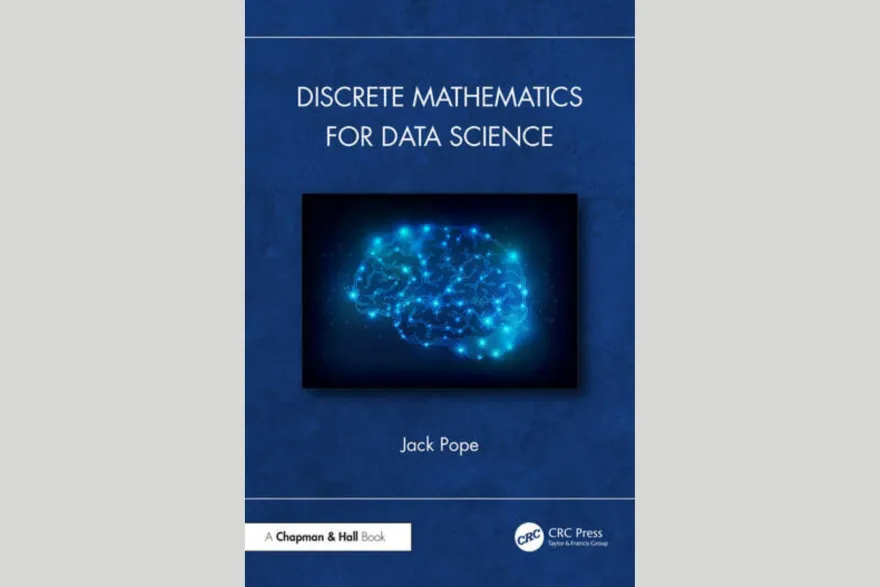 this is a photo of NHCC faculty Jack Pope's new book. The cover reads, 'Discrete Mathematics for Data Science' 'Jack Pope' 'A Chapman and Hall Book' 'CRC Press Taylor and Francis Group' the cover of the book is blue and has an outline of a brain, that is illuminated in bright blue dots. 