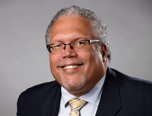 this is a smiling, professional headshot photo of Dr. Charles Talbert, a retired actuarial professional and guest speaker at NHCC. 