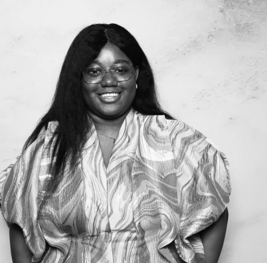 this is a black and white photobooth photo of NHCC student, Beloved smiling and holding up her Student Life Award certificate.
