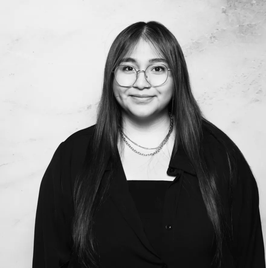 this is a black and white photobooth photo of NHCC student, Lynette smiling and holding up her Student Life Award certificate.