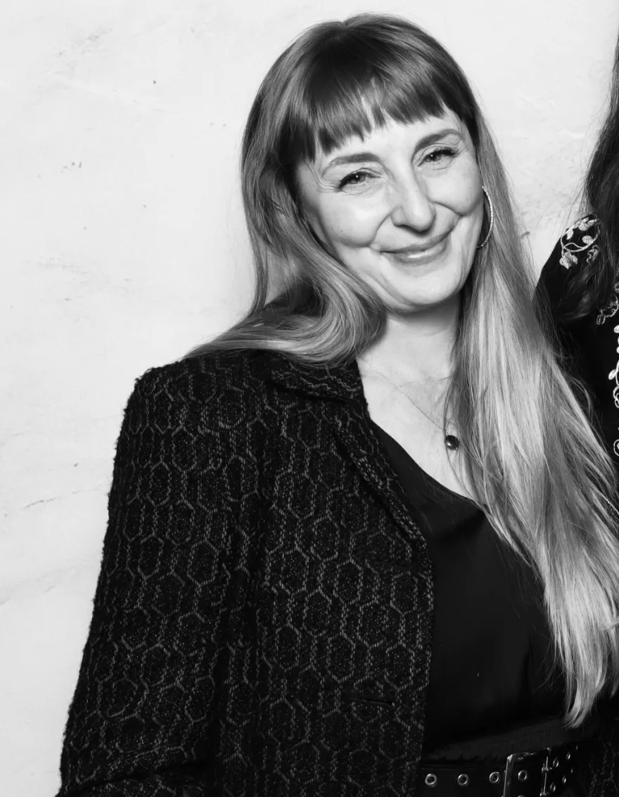 this is a black and white photobooth photo of NHCC faculty, Haley Lasche smiling while taking a photo at the Student Life Awards Banquet.