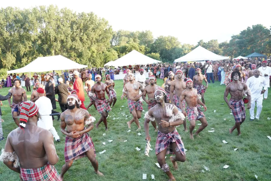 Traditional dancers perform before a large crowd at an outdoor IgboFest cultural celebration.