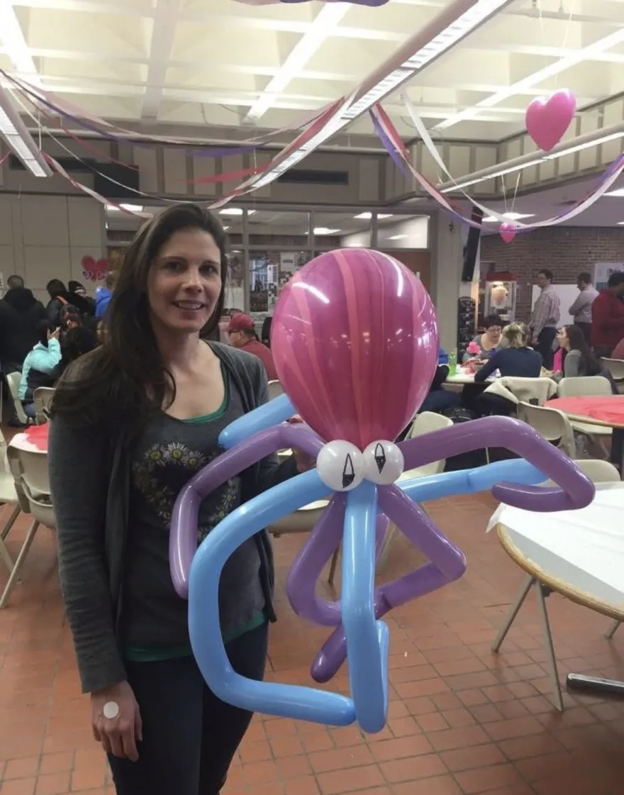 this is a smiling photo of NHCC graduate, Kari Struble, when she was a student at NHCC, celebrating We Love Our Students Day in the Campus Center in 2016. She is holding an octopus made out of balloons, for a fun party activity snapshot. 