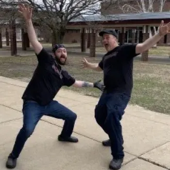 Staff from Brisbane's Revenge posing with their arms extended 